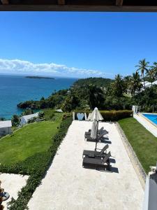 a patio with chairs and a view of the ocean at Vista Mare Samaná in Punta Balandra