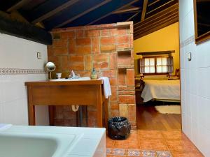 a bathroom with a sink and a brick wall at Posada la Punvieja in Los Tojos +47 photos
