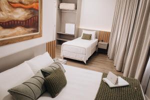 a living room with two beds and a couch at Hotel Daieli in Otacílio Costa