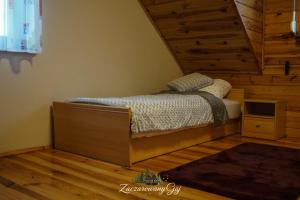 a bedroom with a bed in the corner of a room at Zaczarowany Gaj in Gaj Grzmięca