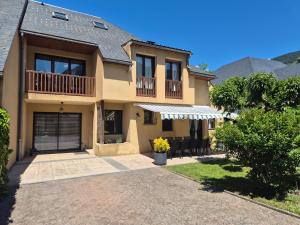 a large house with a balcony and a patio at Le nid des Pyrénées in Vielle-Aure