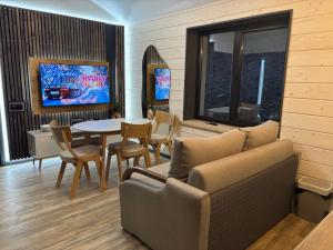 a living room with a couch and a table with chairs at Sky hugs cottage in Volosyanka