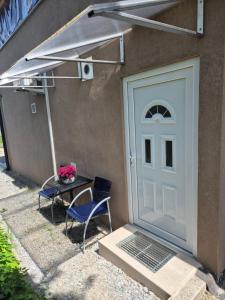 a door with a table and two chairs next to a house at Garsonjera Alina in Zgornje Gameljne