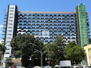 a large building with cars parked in front of it at ABC Apart Hotel in Brasília