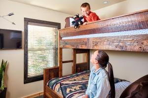 a young boy sitting on top of a bunk bed at Waybound Yosemite in Fish Camp