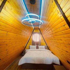 a bedroom with a bed in a wooden wall at اكواخ السوسنة السوداء in Ajloun +46 photos