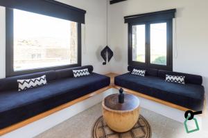 a living room with two blue couches and a table at Hotiday Suites Mykonos in Mikonos