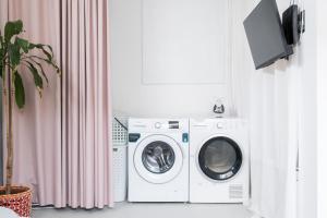 a laundry room with a washing machine and a tv at 4BR, Garden & BBQ, 5min to Milícias Beach, Easy Park, Casa Yucca in São Roque +20 photos