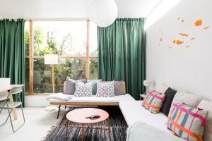 a living room with green curtains and a white couch at 4BR, Garden & BBQ, 5min to Milícias Beach, Easy Park, Casa Yucca in São Roque