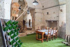 a dining room with a table and chairs and wine bottles at Parnaydisiaque in Parnay