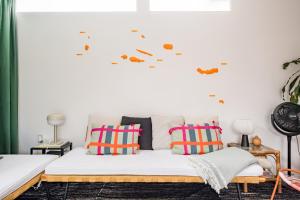 a bedroom with a bed with colorful pillows at 4BR, Garden & BBQ, 5min to Milícias Beach, Easy Park, Casa Yucca in São Roque