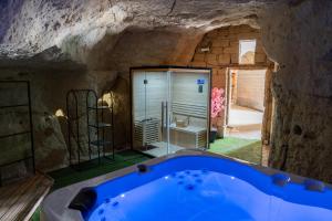 a bathroom with a blue tub in a cave at Parnaydisiaque in Parnay