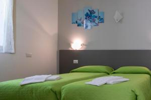 a bedroom with a green bed with two towels on it at La Collina dei Fiori in Vercana +59 photos