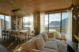 a living room with a white couch and a table and chairs at Secluded Lodge - Stunning Views! in Storøya