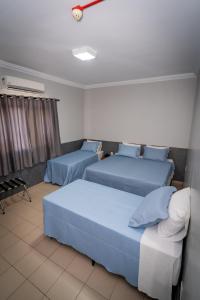 a hotel room with two beds and a window at Bandeirantes Hotel in Cuiabá +47 photos