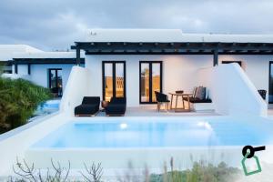 a villa with a swimming pool and a house at Hotiday Suites Mykonos in Mikonos