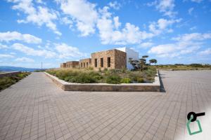 a brick building with a blue sky in the background at Hotiday Suites Mykonos in Mikonos