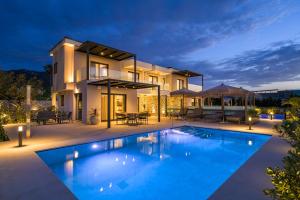 a villa with a swimming pool at night at Mama Rosa Luxury Villas with private pools in Zipárion