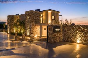 a building with a stone wall with lights on it at Mama Rosa Luxury Villas with private pools in Zipárion