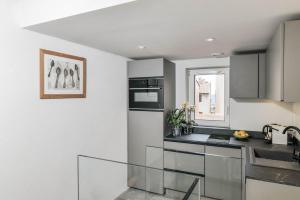 a kitchen with white walls and stainless steel appliances at Maison entière à 100m de la mer in Antibes
