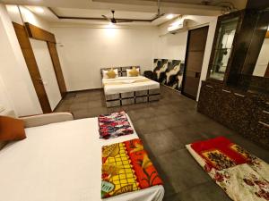 a room with a bed and a couch in it at Sunleaf Palace in Pune