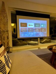 a large flat screen tv in a living room at Villa Issima Samos, Breathtaking Sea View & Jacuzzi in Samos