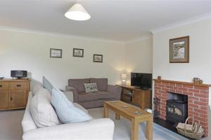 a living room with a couch and a fireplace at 3 Bed in Aldringham oc-pcot in Aldringham