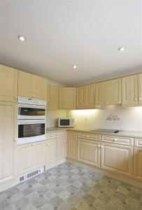 a kitchen with wooden cabinets and white appliances at 3 Bed in Aldringham oc-pcot in Aldringham