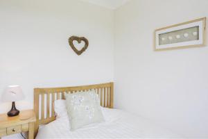 a bedroom with a bed with a heart on the wall at 3 Bed in Aldringham oc-pcot in Aldringham +3 photos