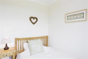 a bedroom with a bed and a heart on the wall at 3 Bed in Aldringham oc-pcot in Aldringham