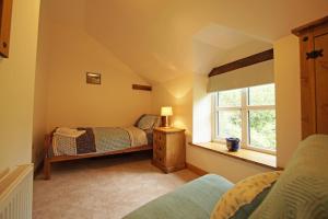 a bedroom with a bed and a window at Hen Gapel in Aberhosan