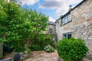 an old stone house with a garden in front of it at 2 Bed in Bakewell oc-91038 in Bakewell