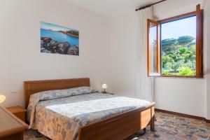 a bedroom with a bed and a large window at Passeggiata Alla Spiaggia in Campo nell'Elba