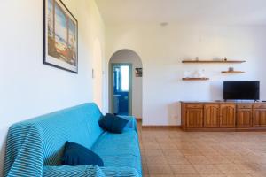 a blue couch in a living room with a tv at Passeggiata Alla Spiaggia in Campo nell'Elba