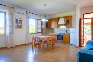 a kitchen and dining room with a table and chairs at Passeggiata Alla Spiaggia in Campo nell'Elba