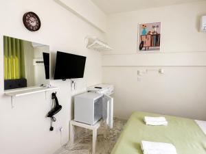 a white room with a bed and a flat screen tv at Smart Comfort RoomN3 with Private Bathroom in best Location Beach 250m in Limassol +3 photos