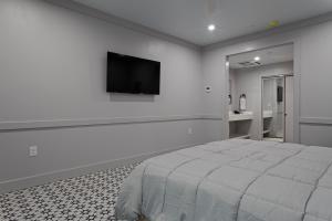 a bedroom with a bed and a flat screen tv on a wall at Hotel Biloxi in Biloxi