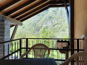 un tavolo e sedie su un balcone con vista sulle montagne di Appartamenti Alpi Graie - Cantoira a Cantoira
