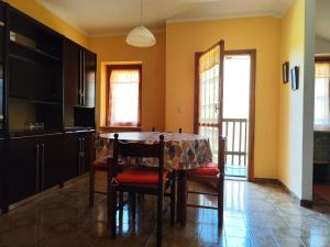 una cucina con tavolo e sedie in una stanza di Appartamenti Alpi Graie - Cantoira a Cantoira Altre 11 foto