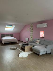 a living room with a couch and a bed at Le pré des noisettes in Angomont