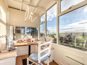 a small kitchen with a table and windows at 2 Bed in Arbroath oc-90316 in Inverkeilor