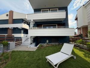 a white chair on the lawn in front of a house at Azur Mare Luxury Villas in Neoi Epivates