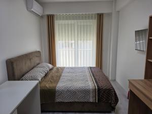 a bedroom with a bed in front of a window at Lux Apartman Gostivar in Gostivar