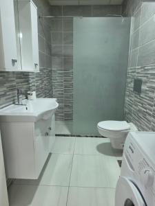 a white bathroom with a sink and a toilet at Lux Apartman Gostivar in Gostivar +9 photos