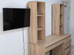 a wooden entertainment center with a tv on a wall at Lux Apartman Gostivar in Gostivar