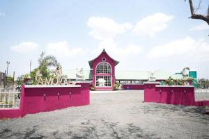 a pink building with a fence in front of it at Amorae Resort in Loni Khurd