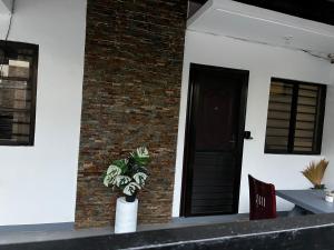 a plant in a vase in front of a building at Travellers Staycation in San Jose del Monte