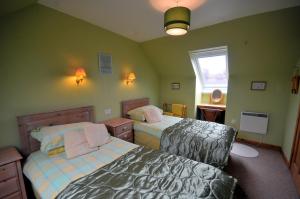 a small bedroom with two beds and a window at Tarven Self Catering cottages in Portree