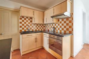 a kitchen with wooden cabinets and a stove top oven at Host & Stay - The Beach in Filey
