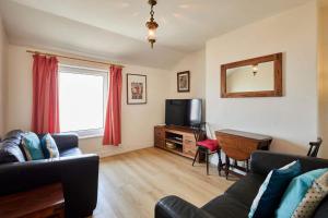 a living room with a couch and a television at Host & Stay - The Beach in Filey